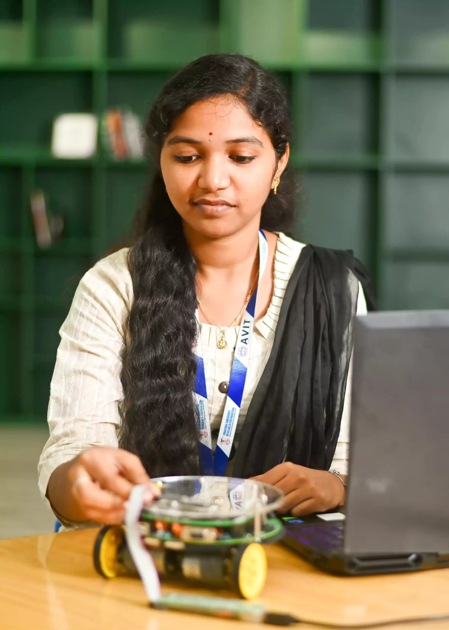 AVIT student working on small robot model